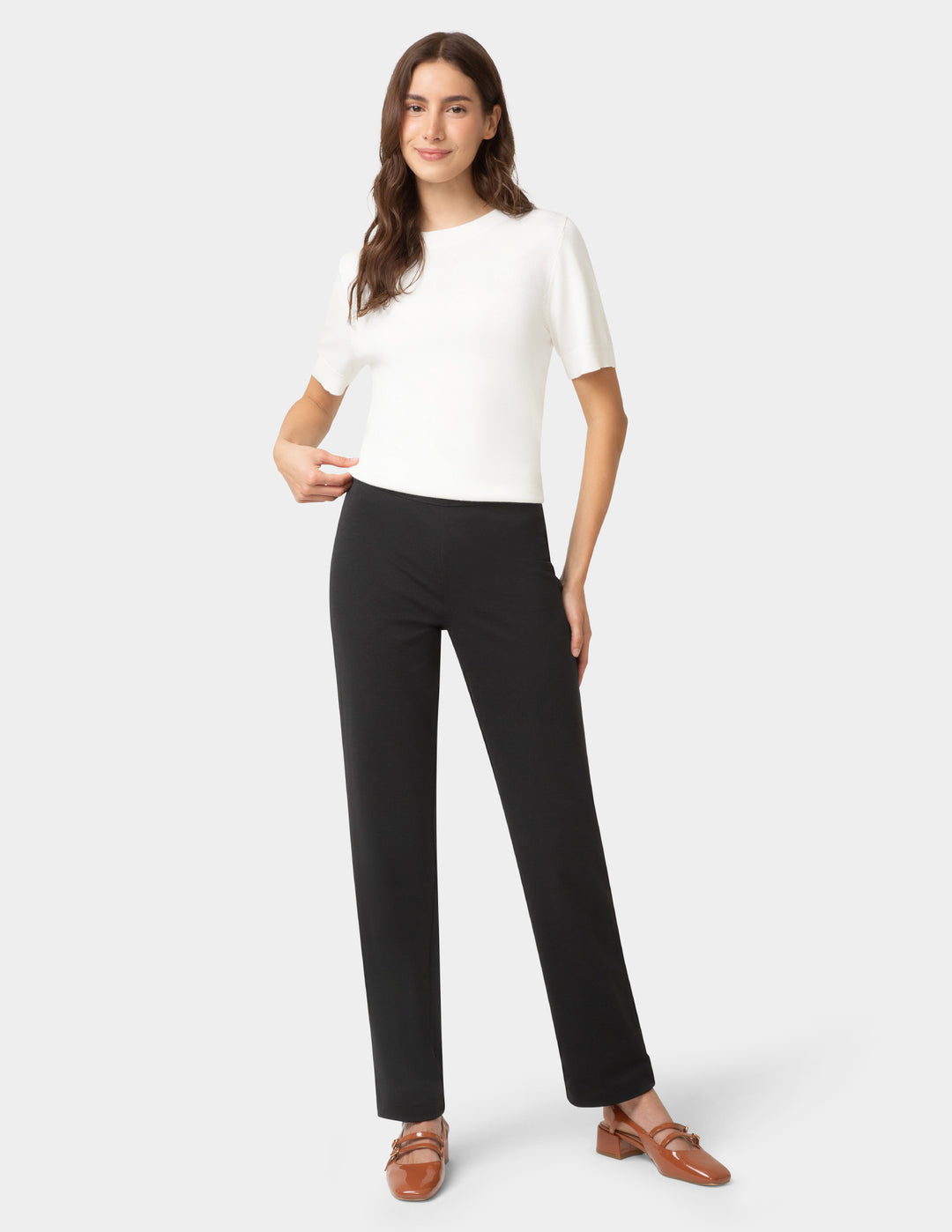 Woman wearing a white top and black pants on a white background