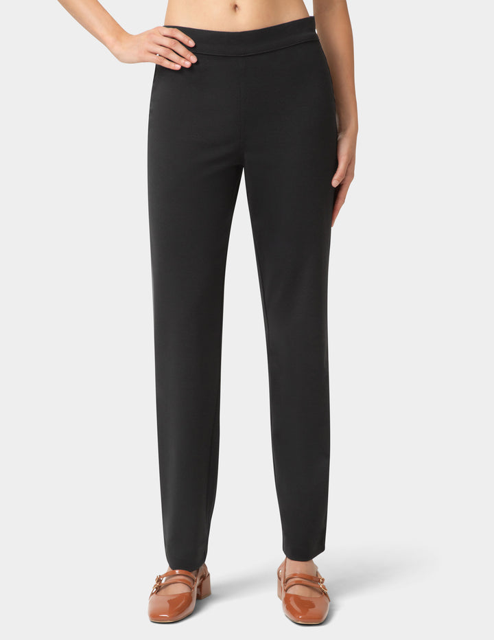 Black pants worn by a person on a white background