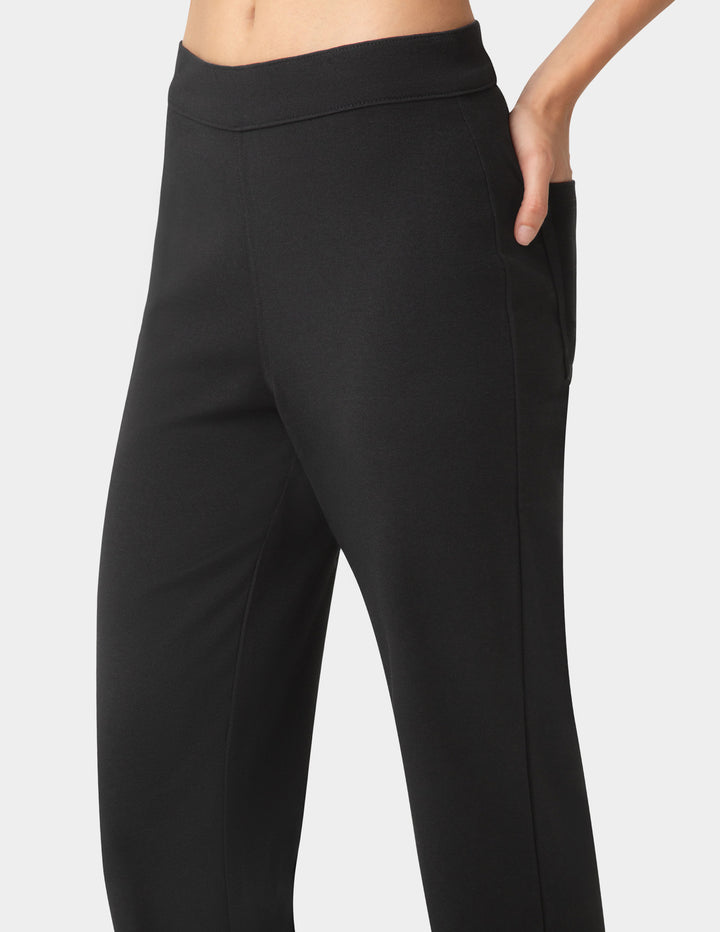Black pants worn by a person on a white background