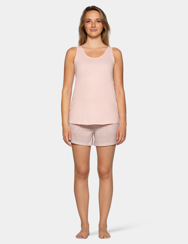 Woman wearing a light pink pajama tank top with stripe boxer shorts