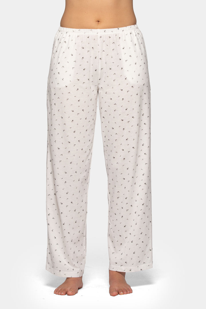 Woman wearing white pajama pants with a flower pattern