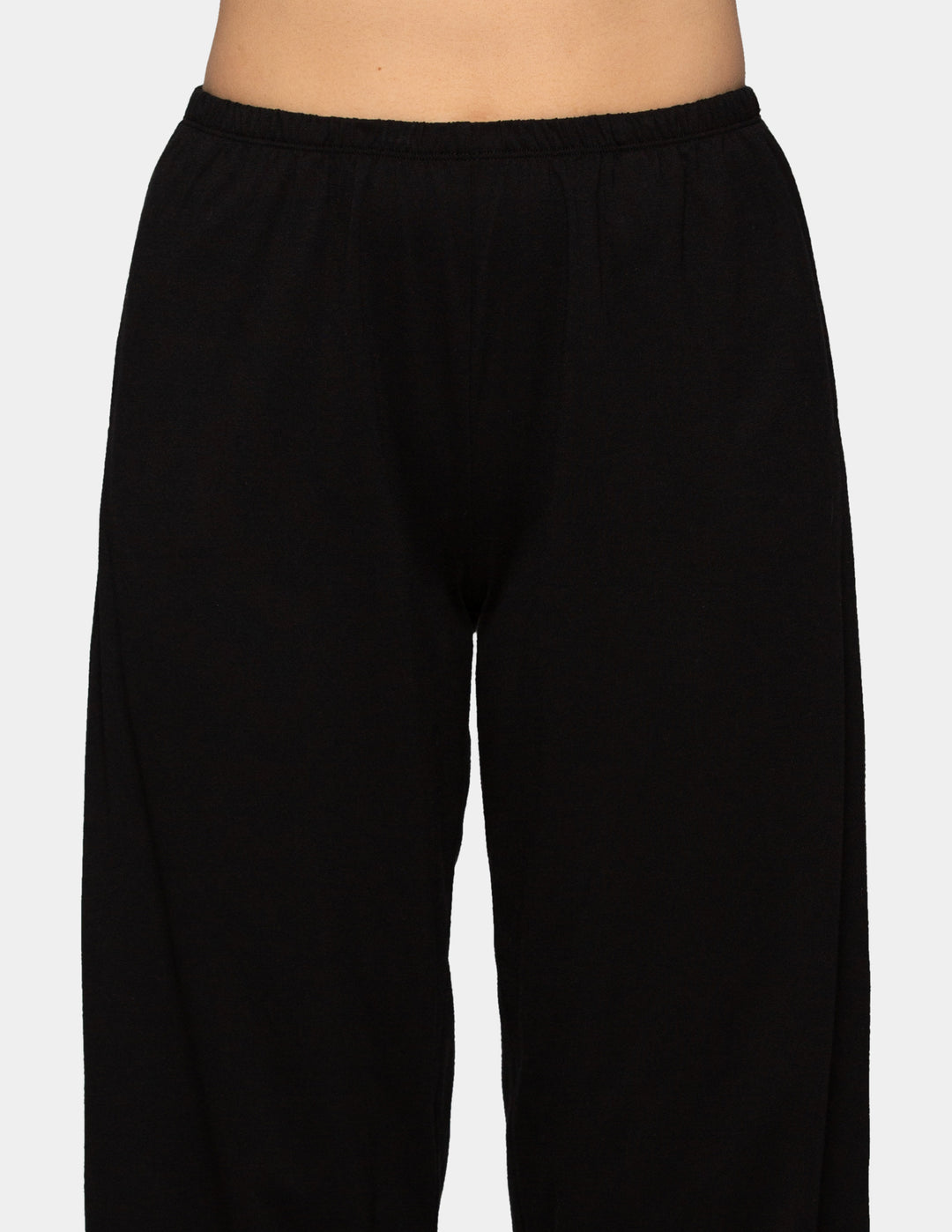 Woman wearing black long pajama pants