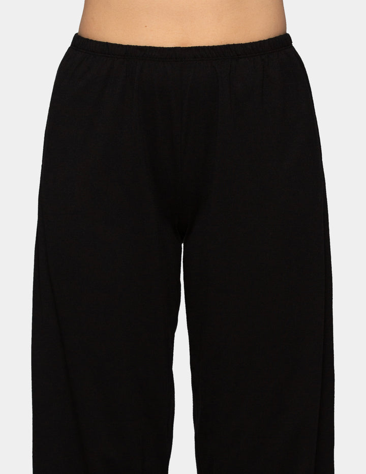 Woman wearing black long pajama pants