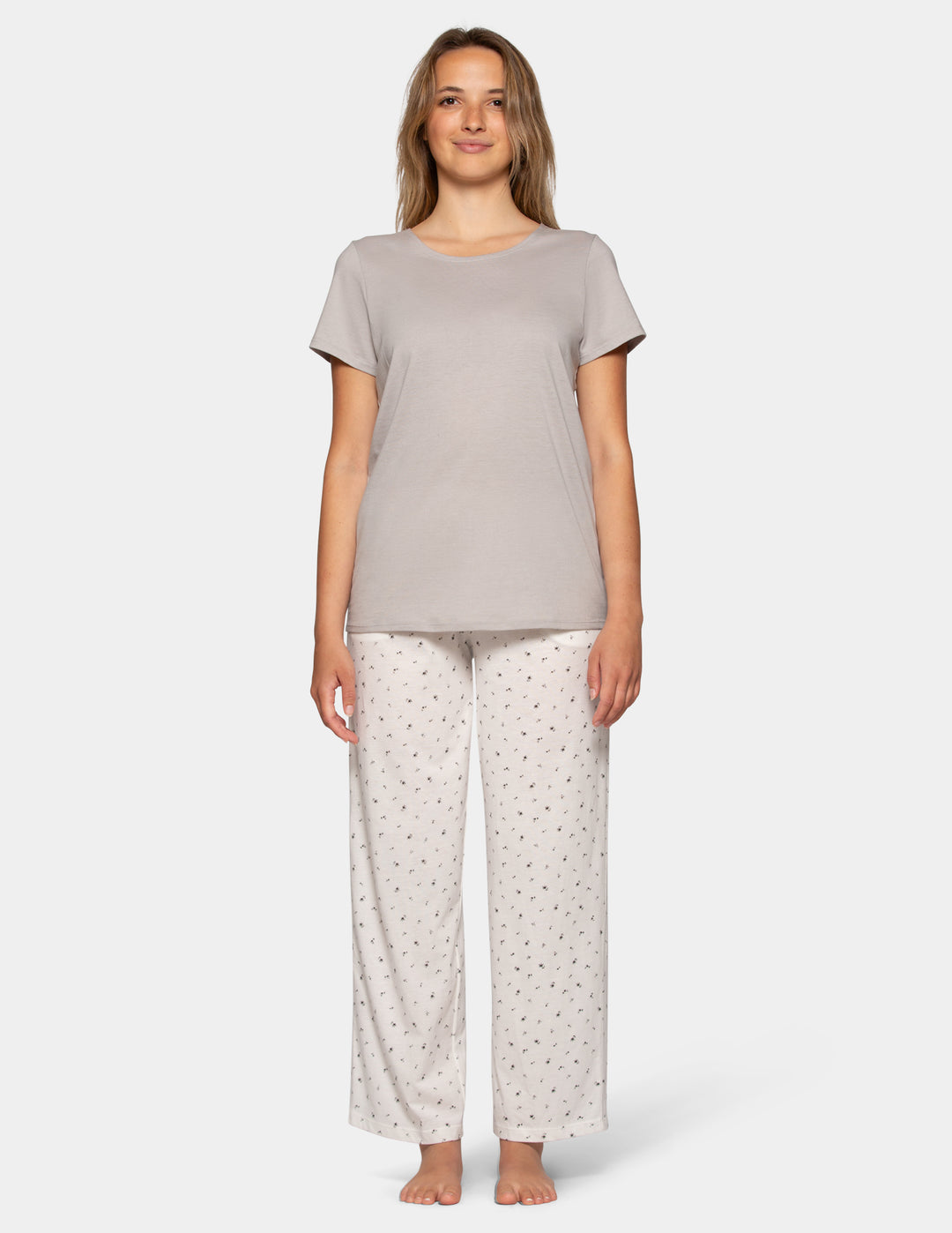 Woman wearing a grey pajama short sleeve tee and flower pattern pants set