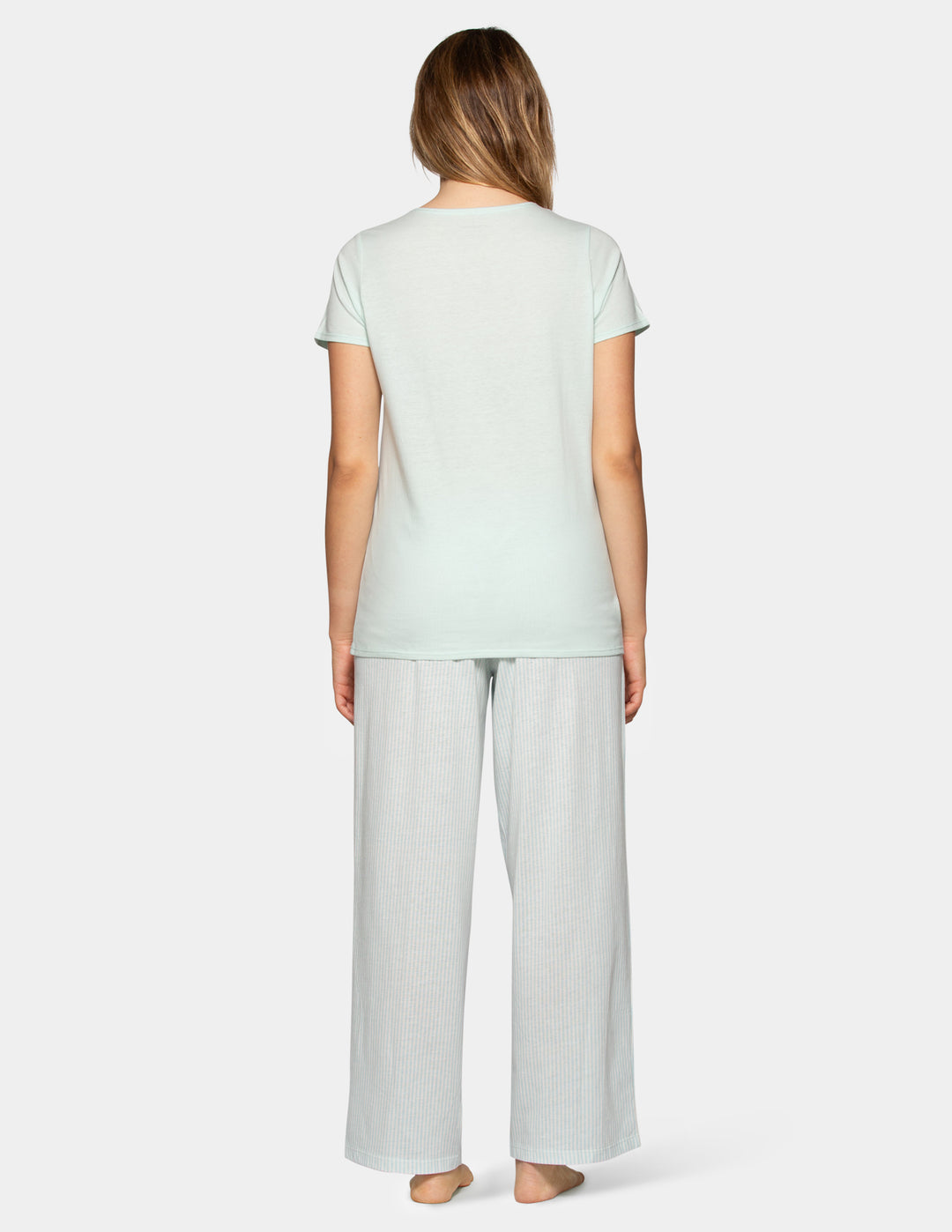 Woman wearing a pale blue pajama short sleeve tee and stripe pants set