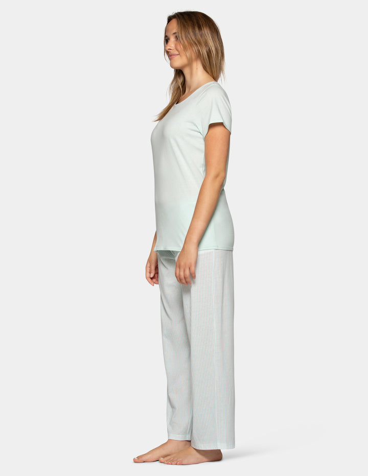 Woman wearing a pale blue pajama short sleeve tee and stripe pants set sideview