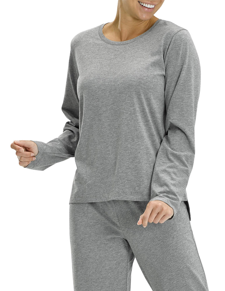 A woman wearing a gray, long sleeve sleep tee with a scoop neck and a high-low hem.