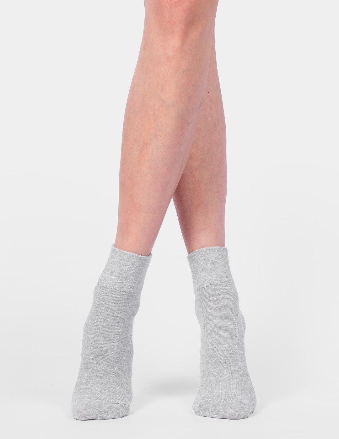 Gray ankle socks worn by a person on a white background
