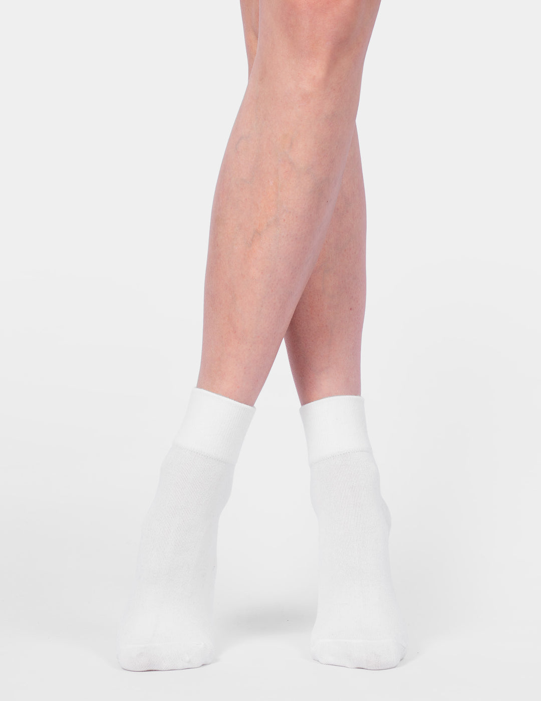 White socks worn by a person on a light gray background