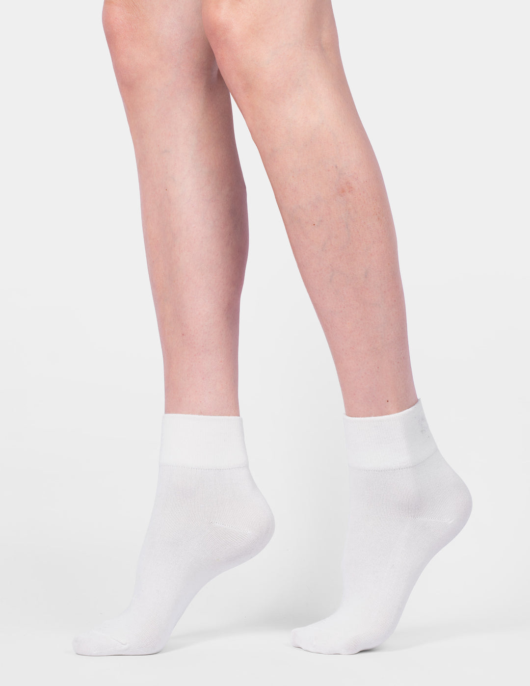White ankle socks worn by a person on a light gray background