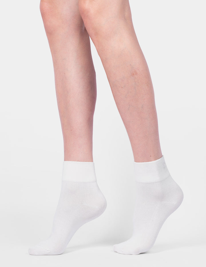 White ankle socks worn by a person on a light gray background