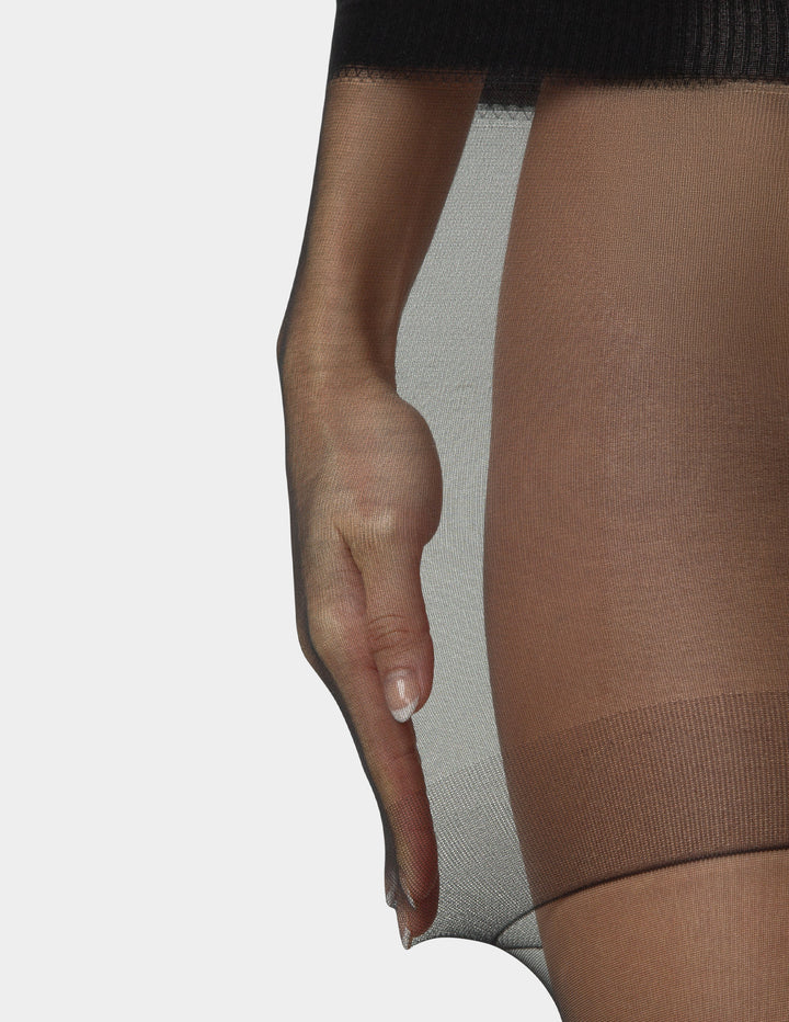 Detail of person stretching black smart support control top sheers on legs