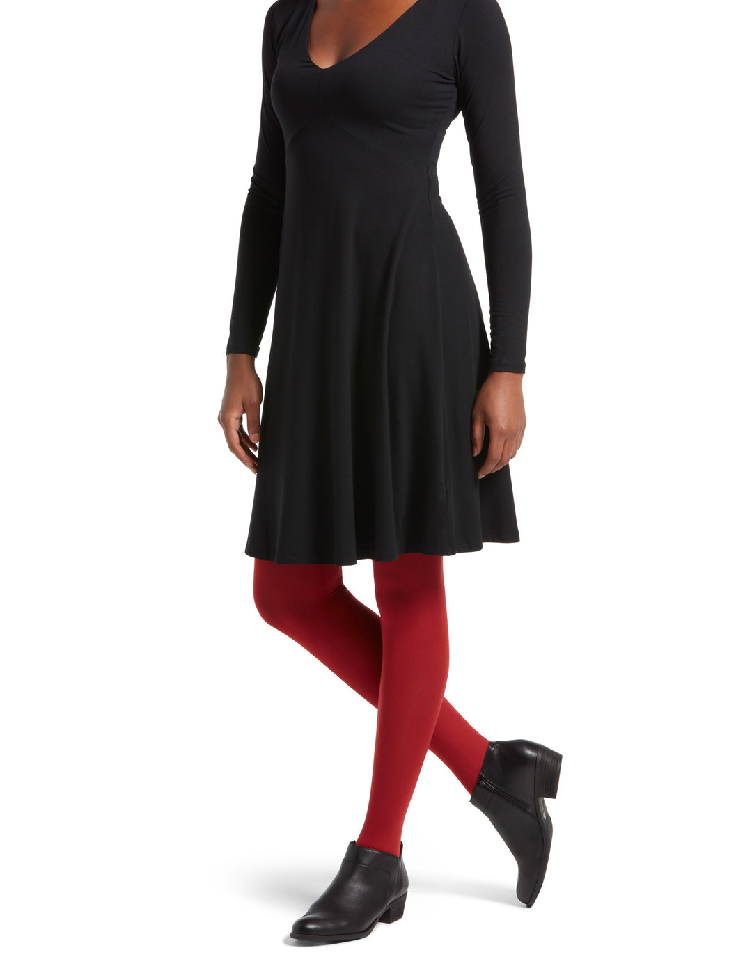 A model wearing red super opaque tights with a mid-rise waistband, paired with a black dress and black boots.
