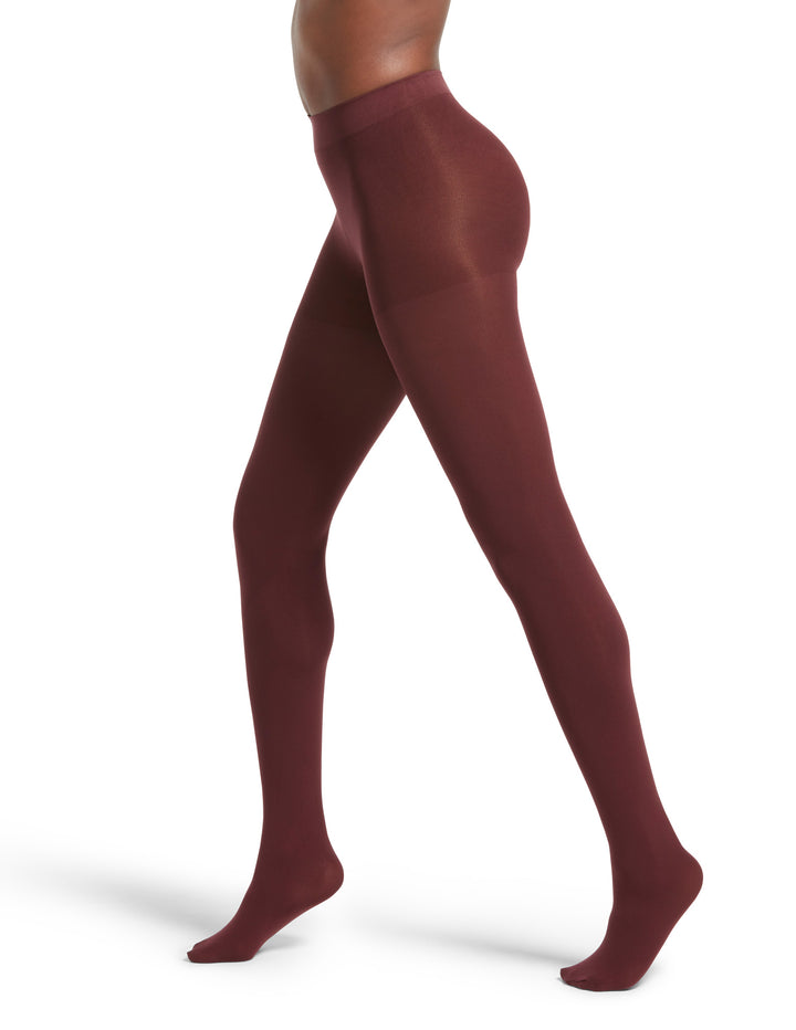 A side view of a person wearing super opaque red tights with a mid-rise waistband.