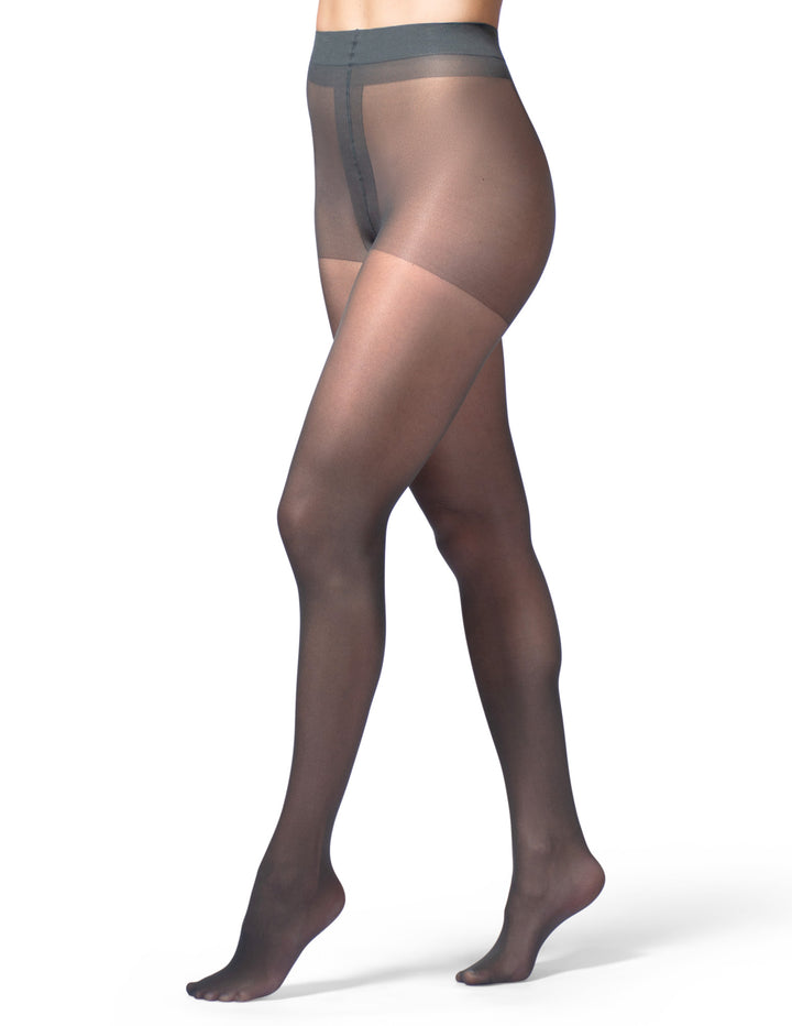 A model's legs wearing sheer almost black control top sheers against a plain white background.