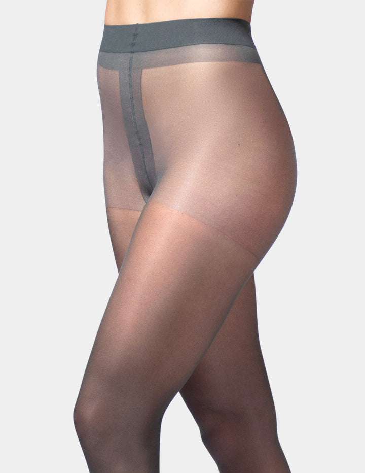 A side view of a model wearing sheer gray hosiery with a wide waistband, set against a solid light gray background.
