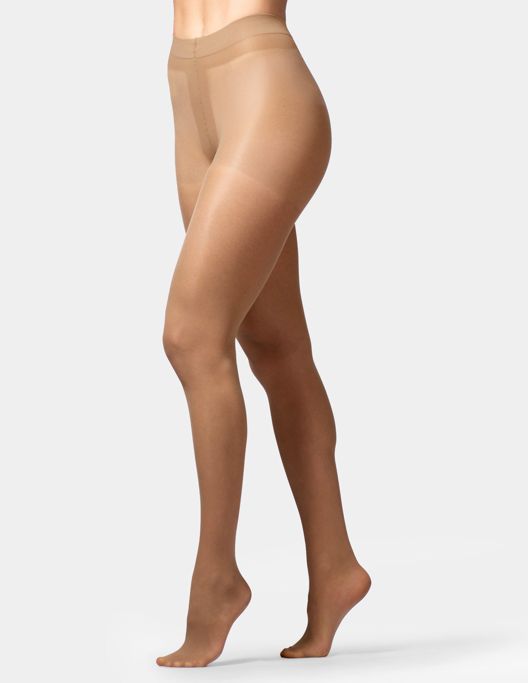 A side profile view of a model wearing sheer, skin-toned hosiery or tights against a clean, light gray studio background.