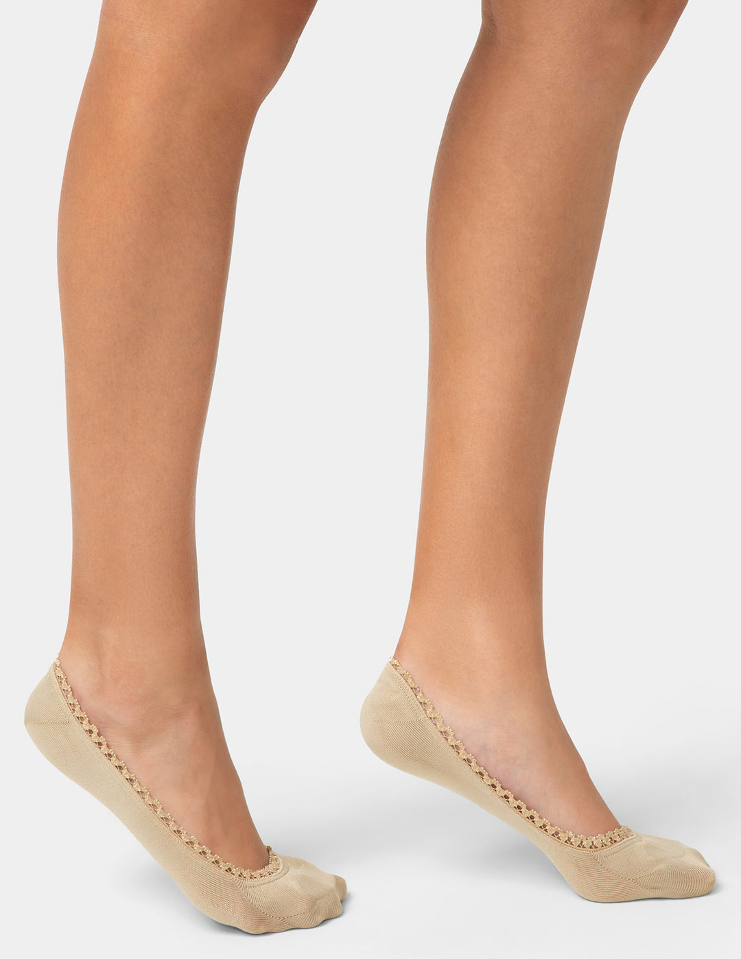Beige sheer socks with lace trim worn by a person on a light gray background