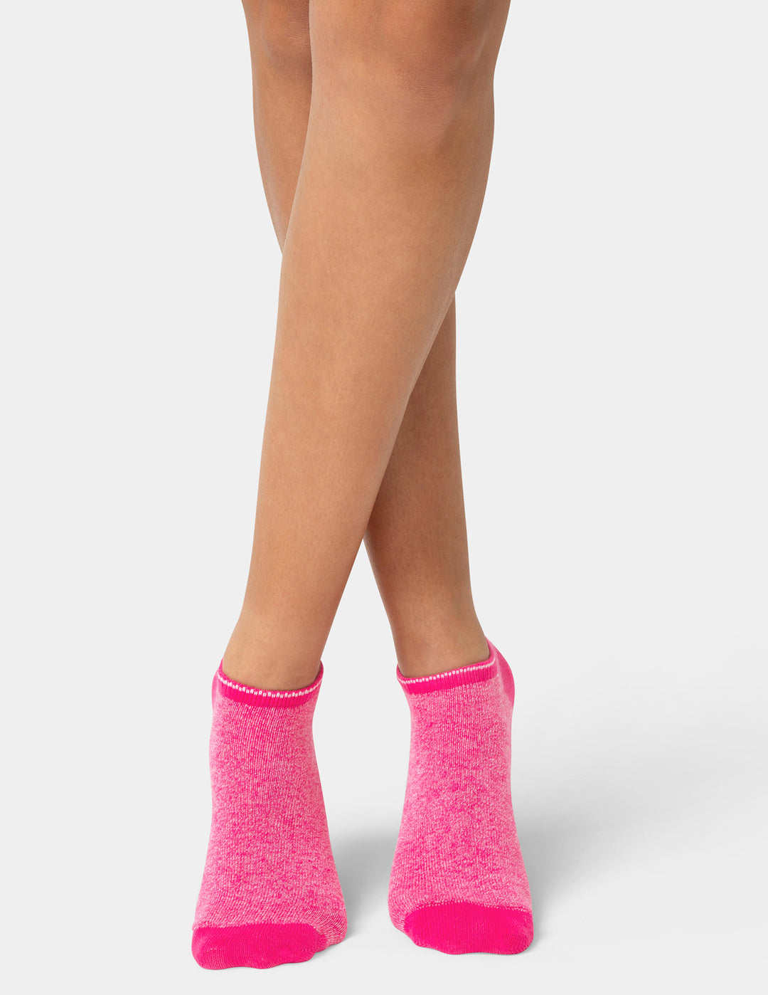 Person wearing bright pink socks on a white background