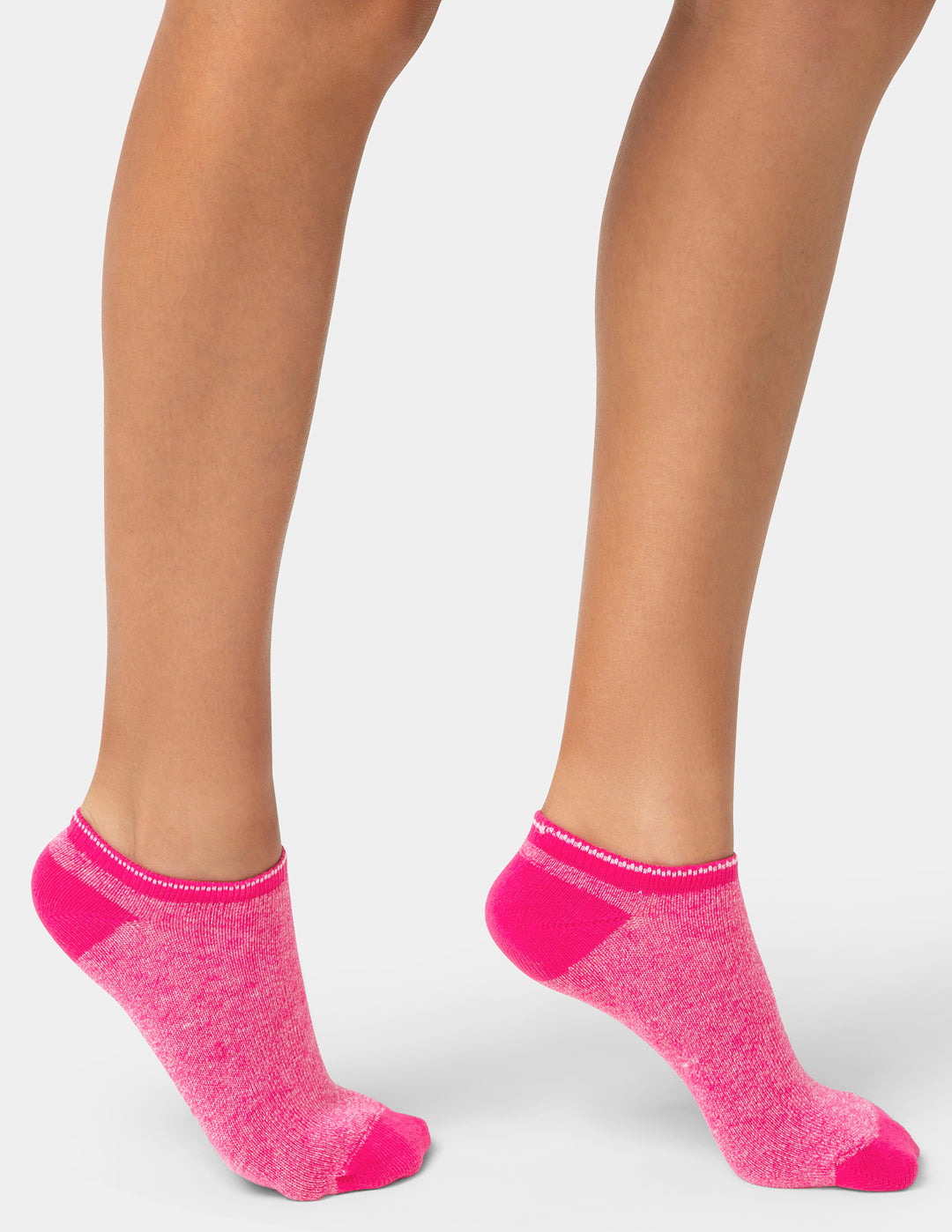 Pink socks worn with beige skin on a white background