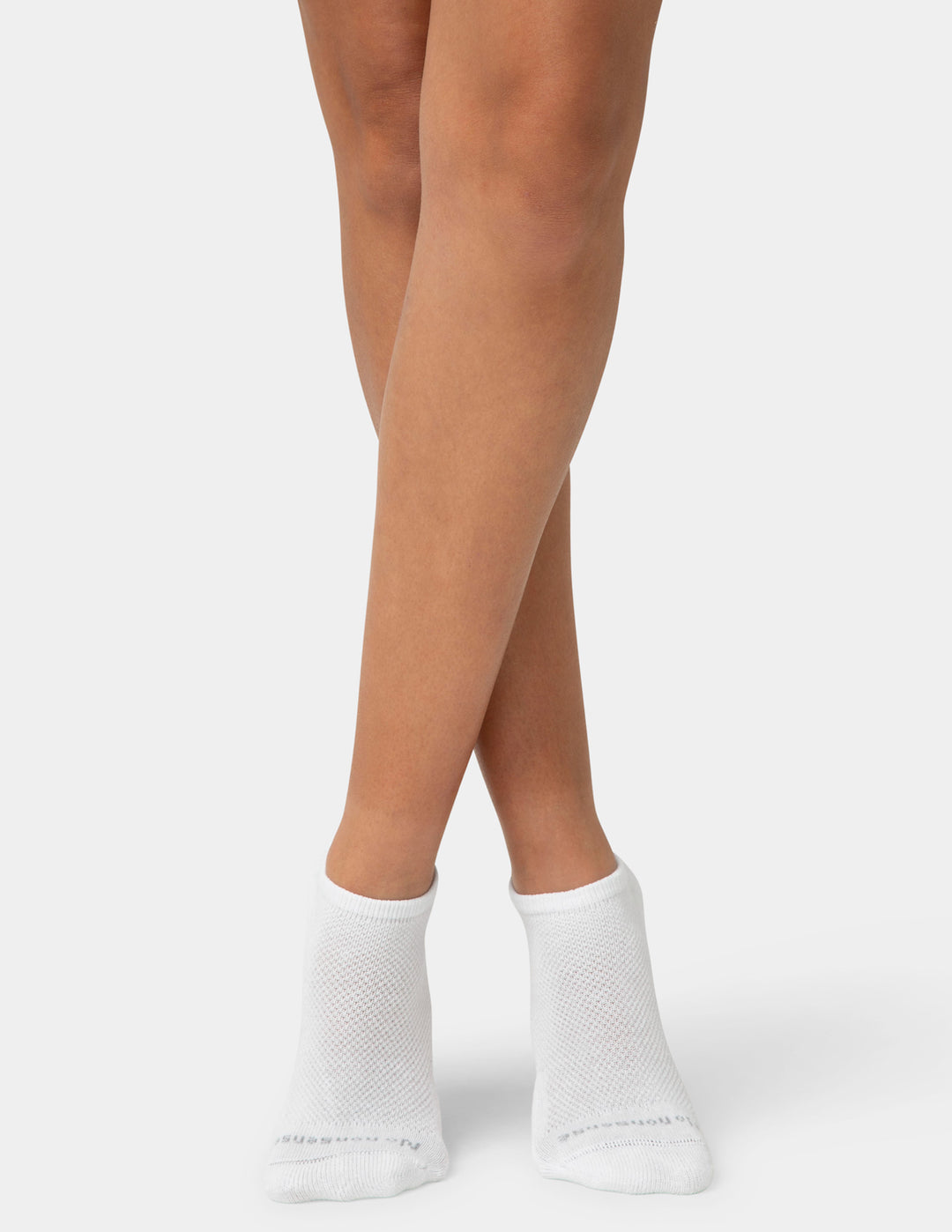 White socks worn with beige skin on a light gray background
