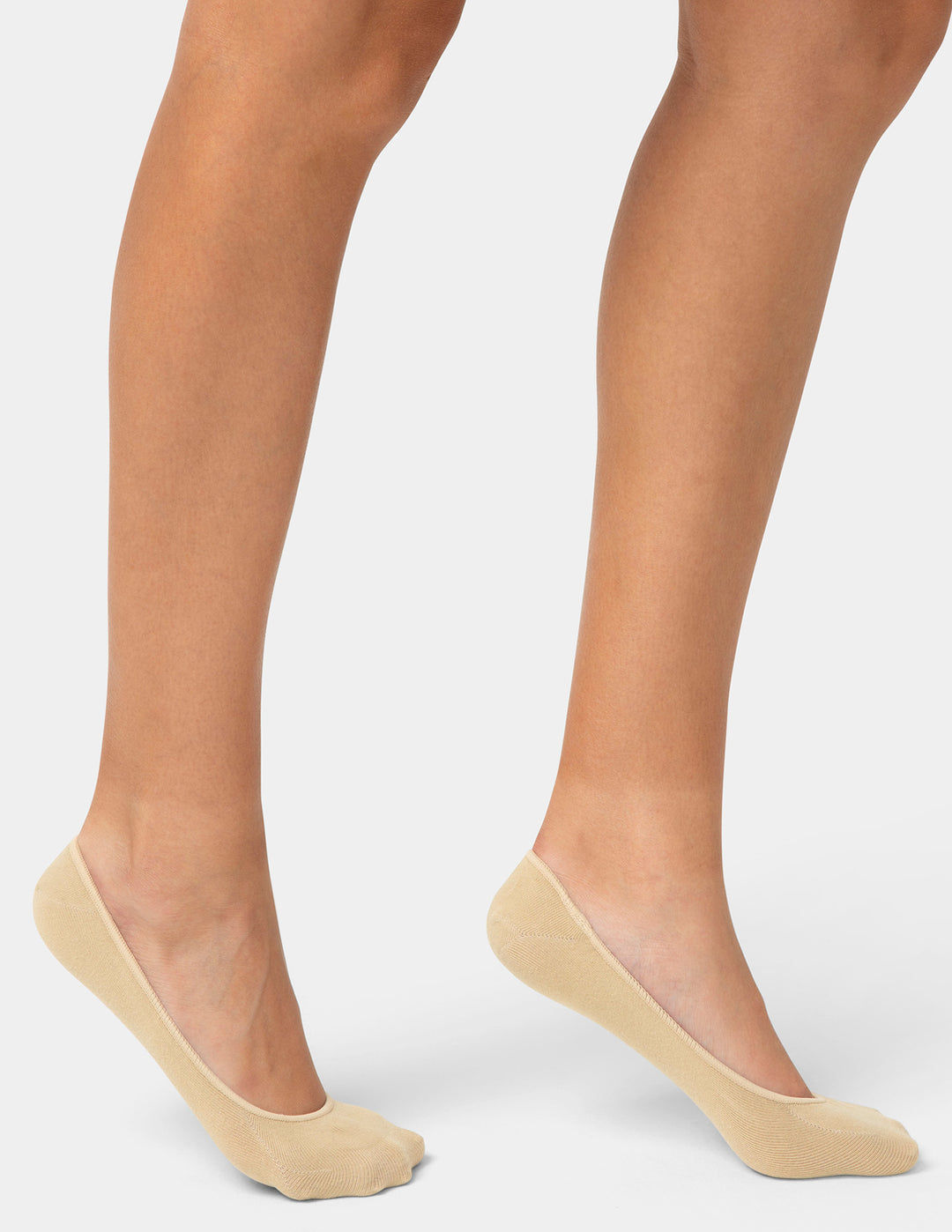 Beige no-show socks worn by a person on a light gray background
