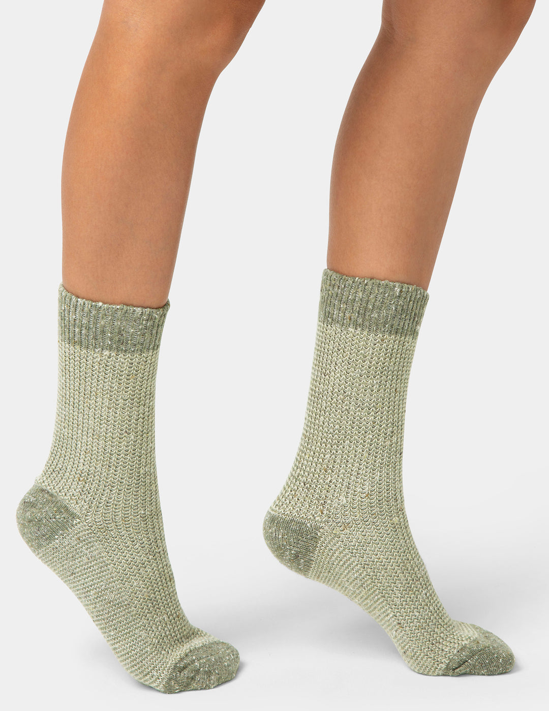 Green socks worn by a person on a white background