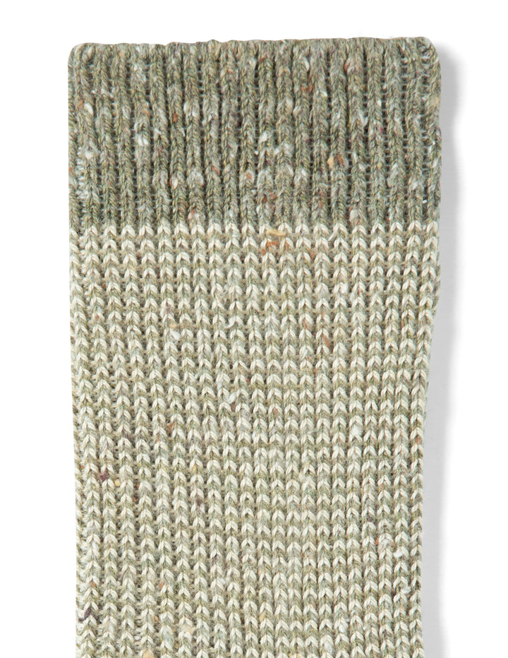 Textured green and beige rug on a white background