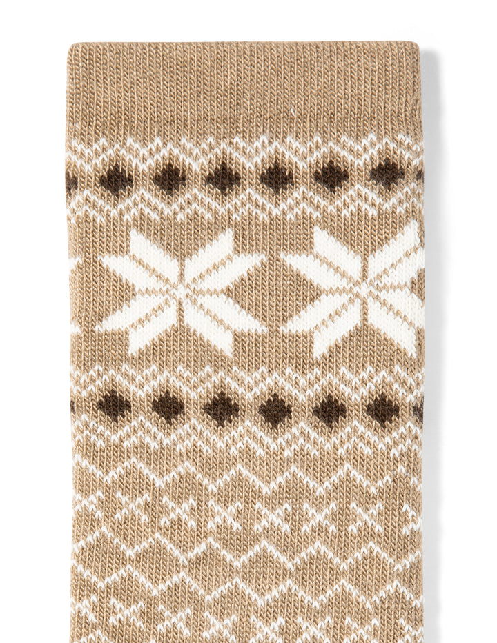 Knitted sock with a pattern of white snowflakes and brown dots on a beige background