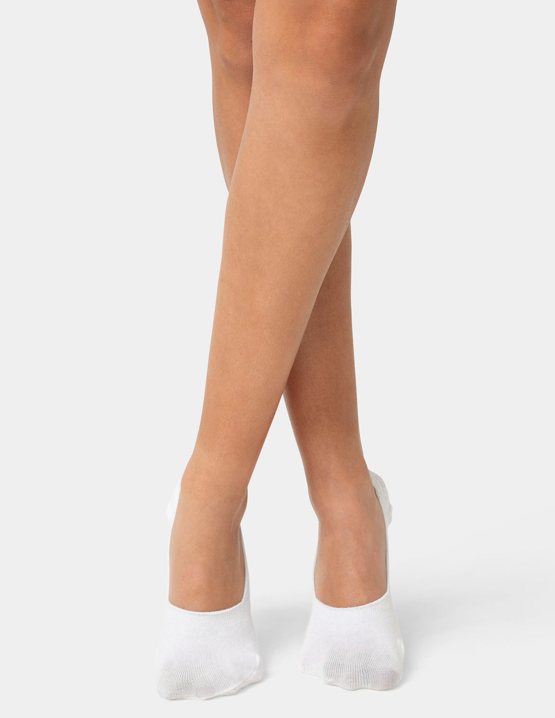 White footie socks worn by a person on a light gray background