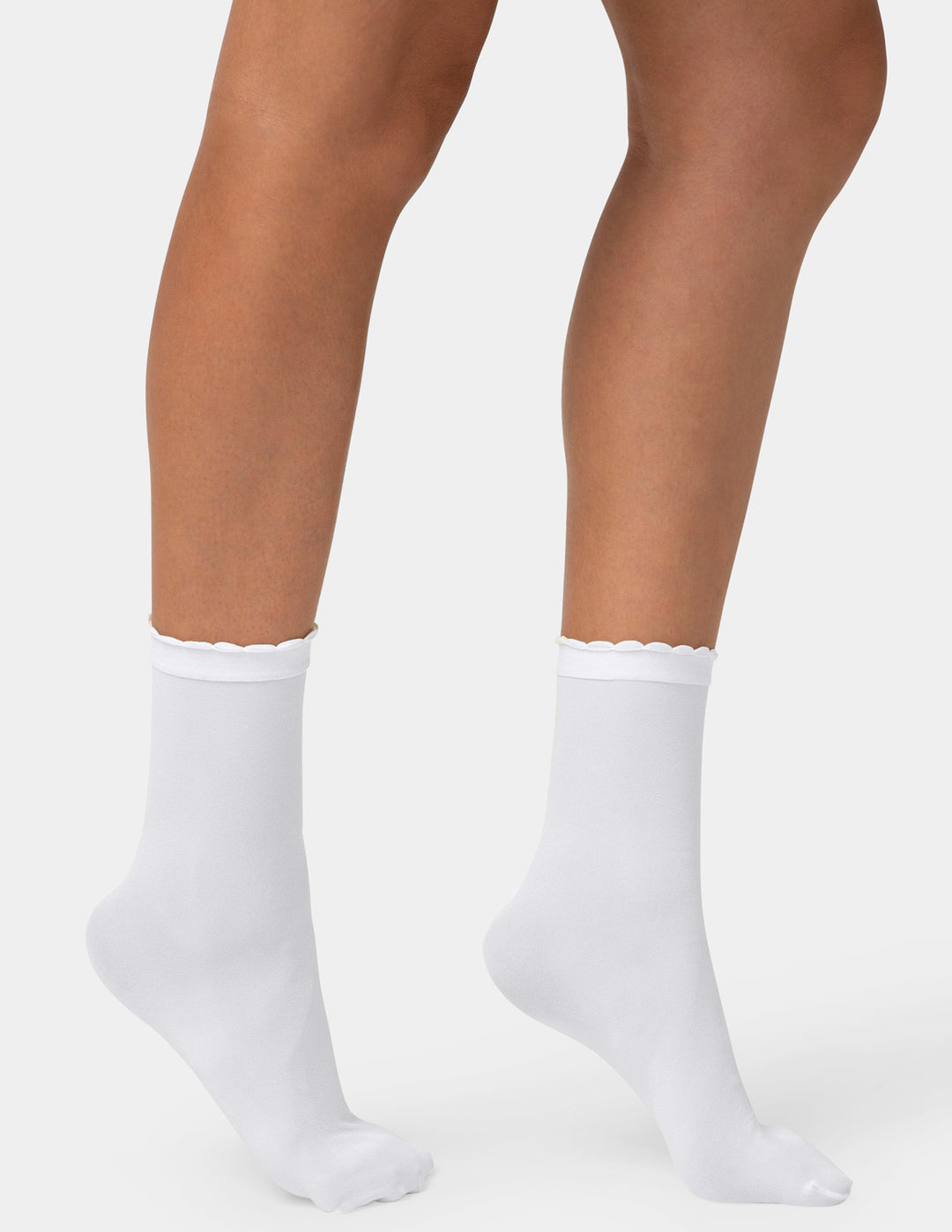 White ankle socks worn on a model's feet, shown against a light gray studio background.