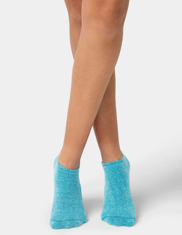 Person wearing blue socks on a white background