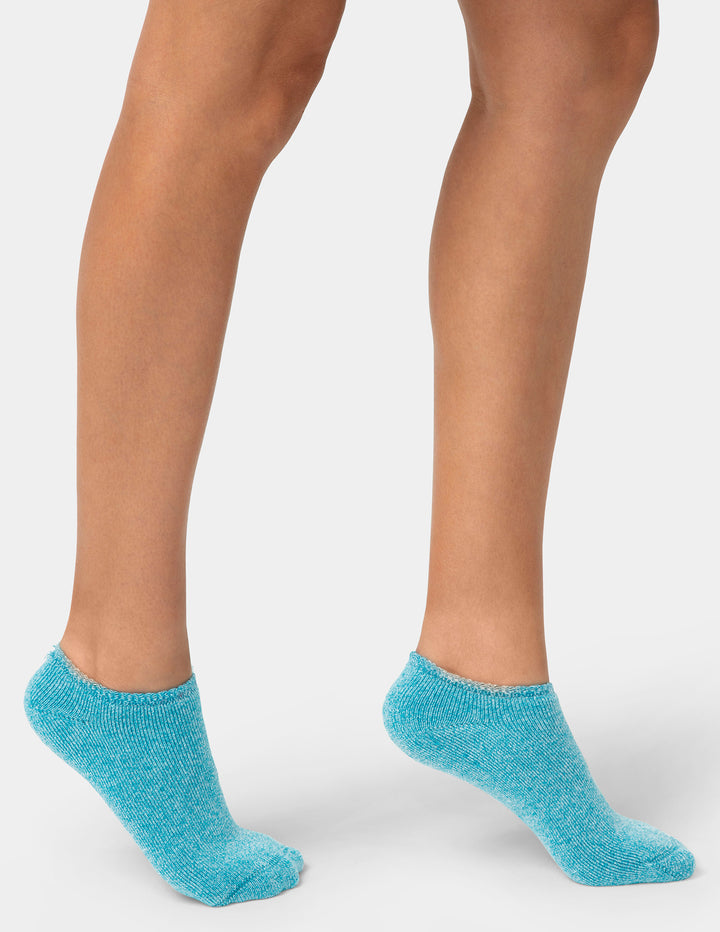 Teal socks worn by a person on a white background