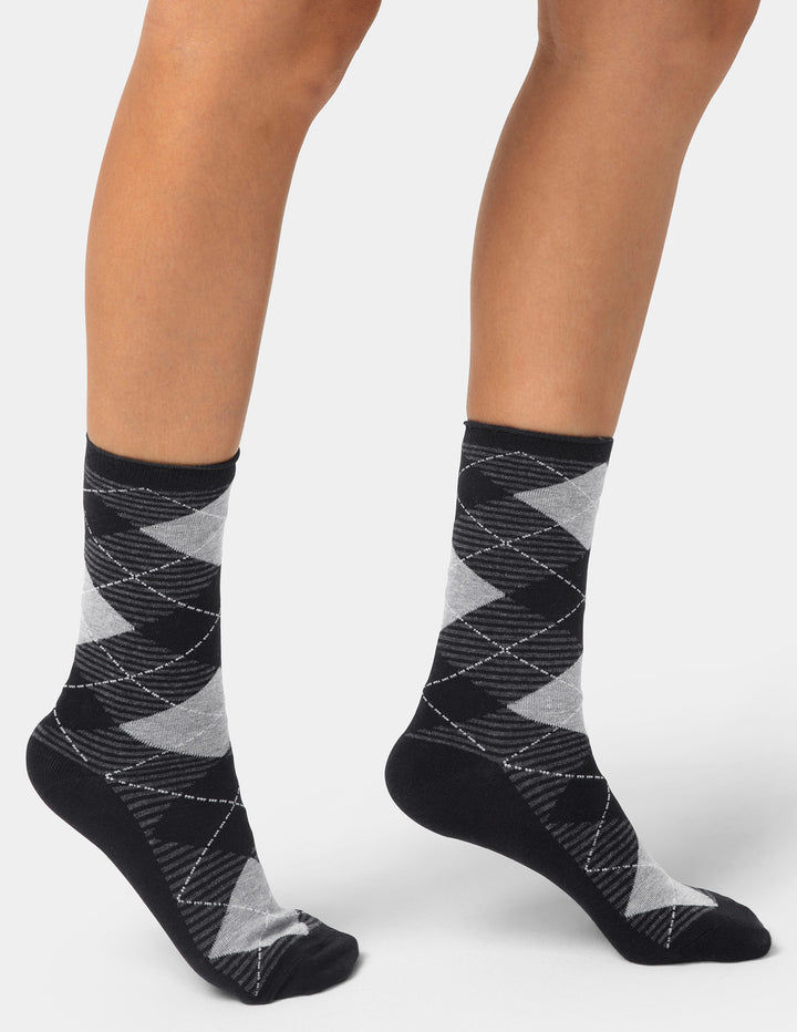 Black and gray patterned socks worn by a person on a white background