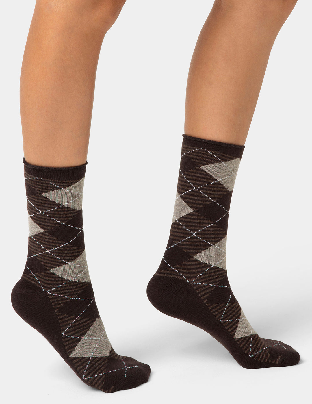 Brown and gray patterned socks worn by a person on a white background