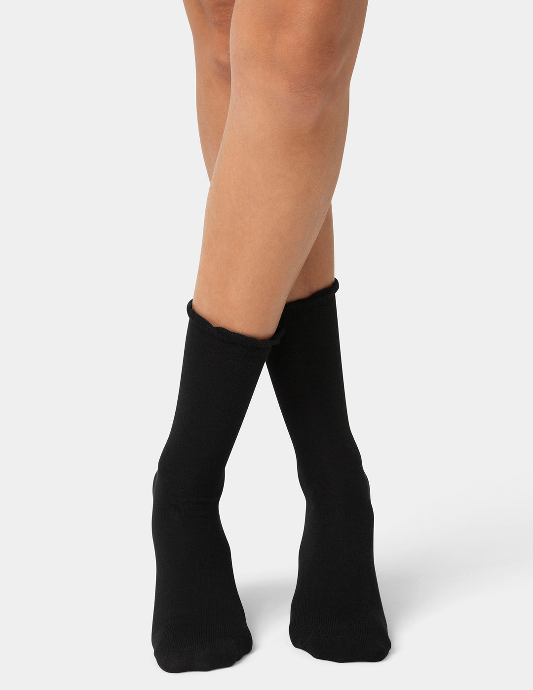 Black crew socks worn by a person on a white background