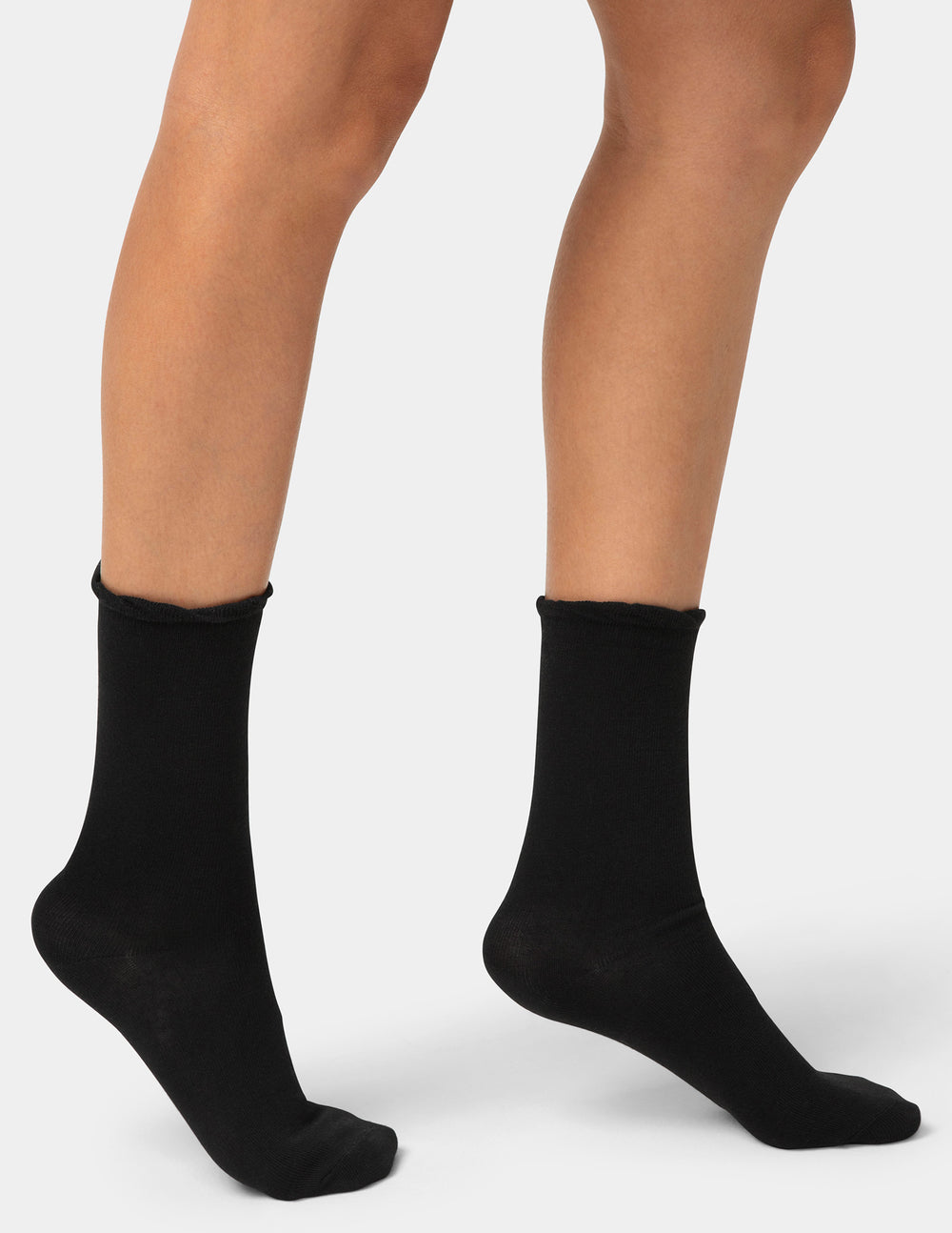 Black socks worn by a person on a white background