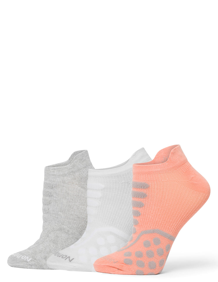 Three pairs of socks in gray, white, and pink with gray dots on a white background