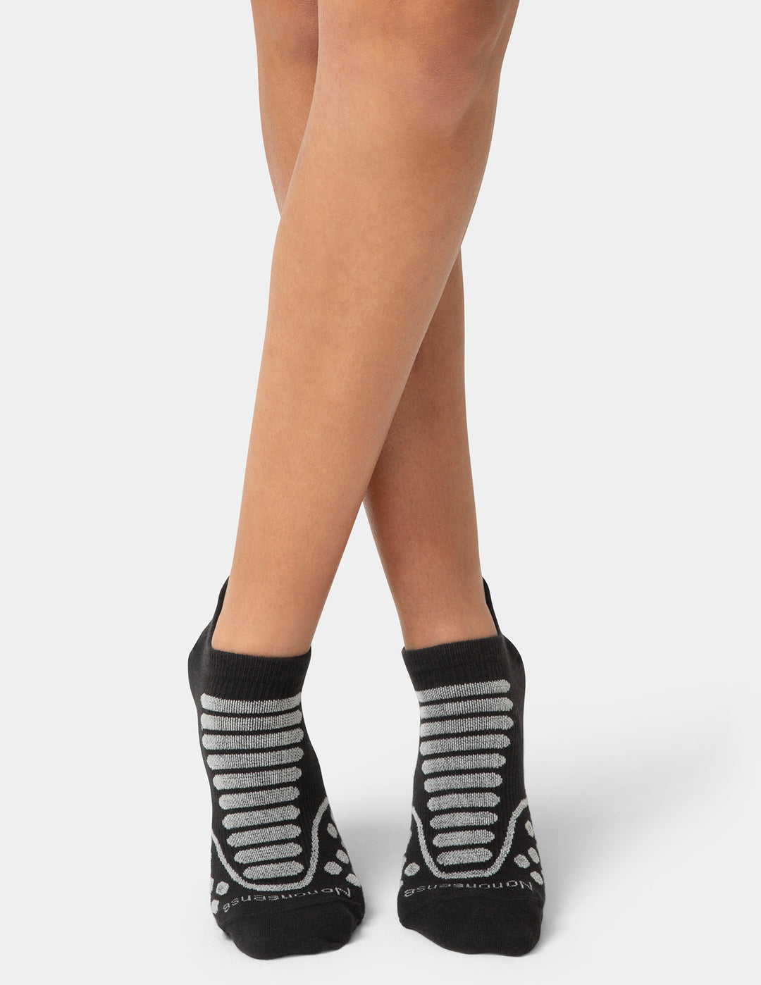 Black socks with gray stripes worn by a person on a white background