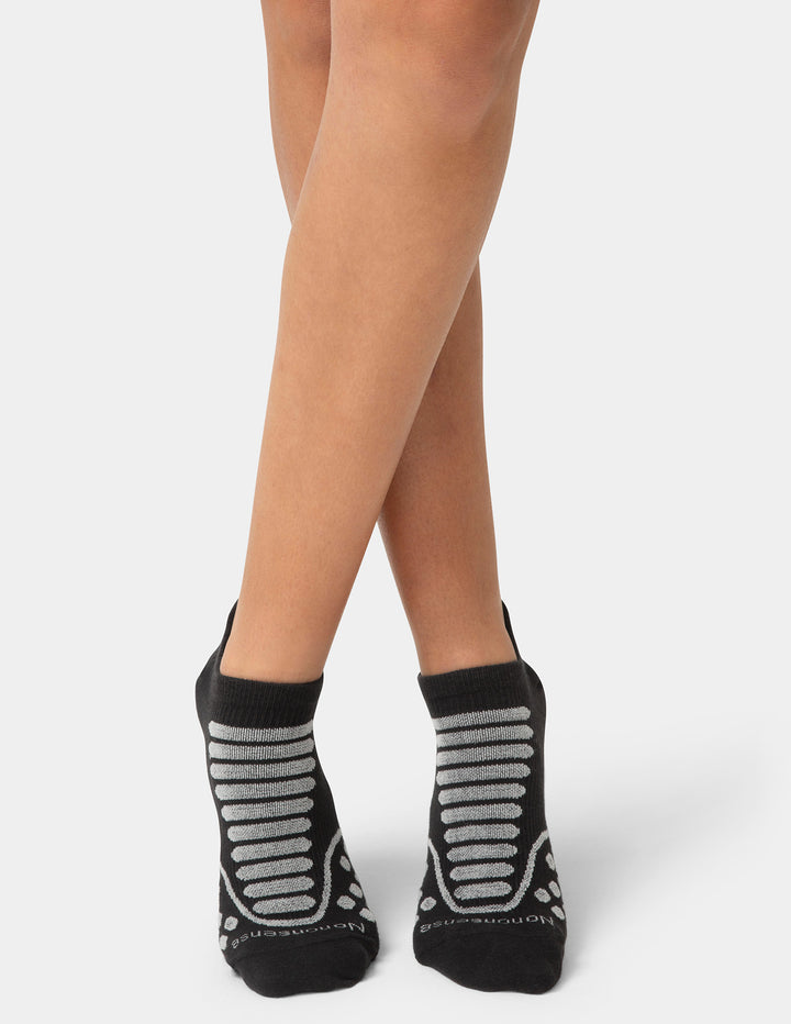 Black socks with gray stripes worn by a person on a white background