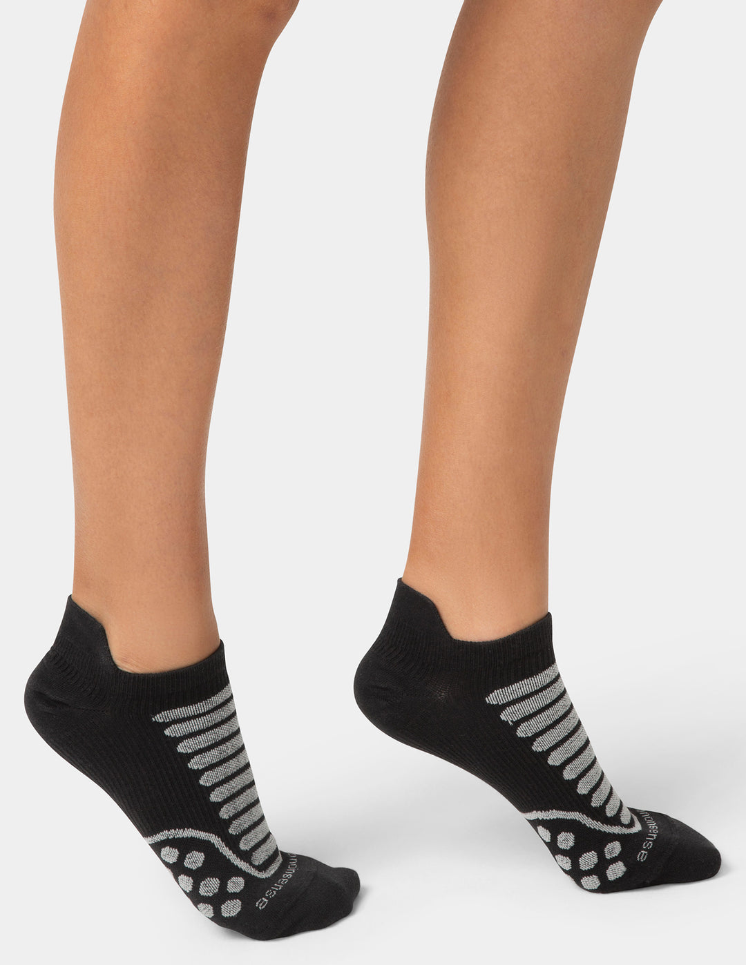 Black socks with gray patterns worn by a person on a white background