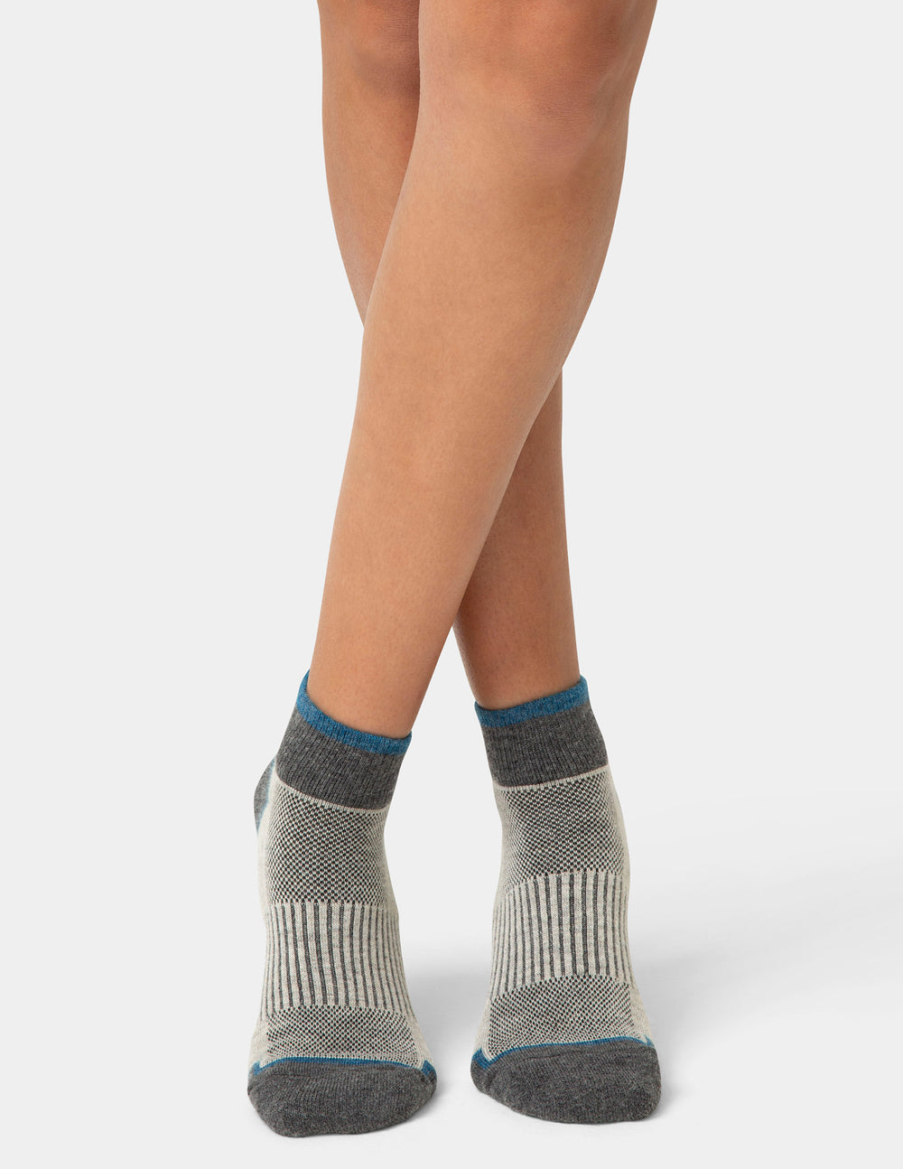 Gray socks with blue accents worn by a person on a white background