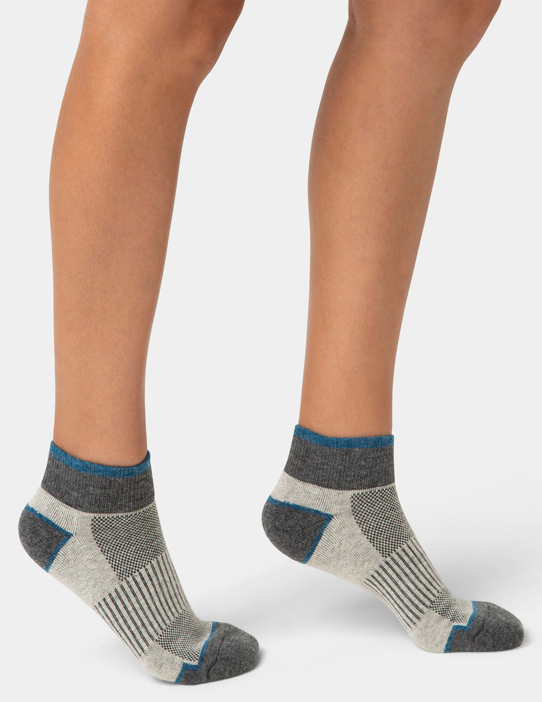 Gray and beige socks worn by a person on a white background