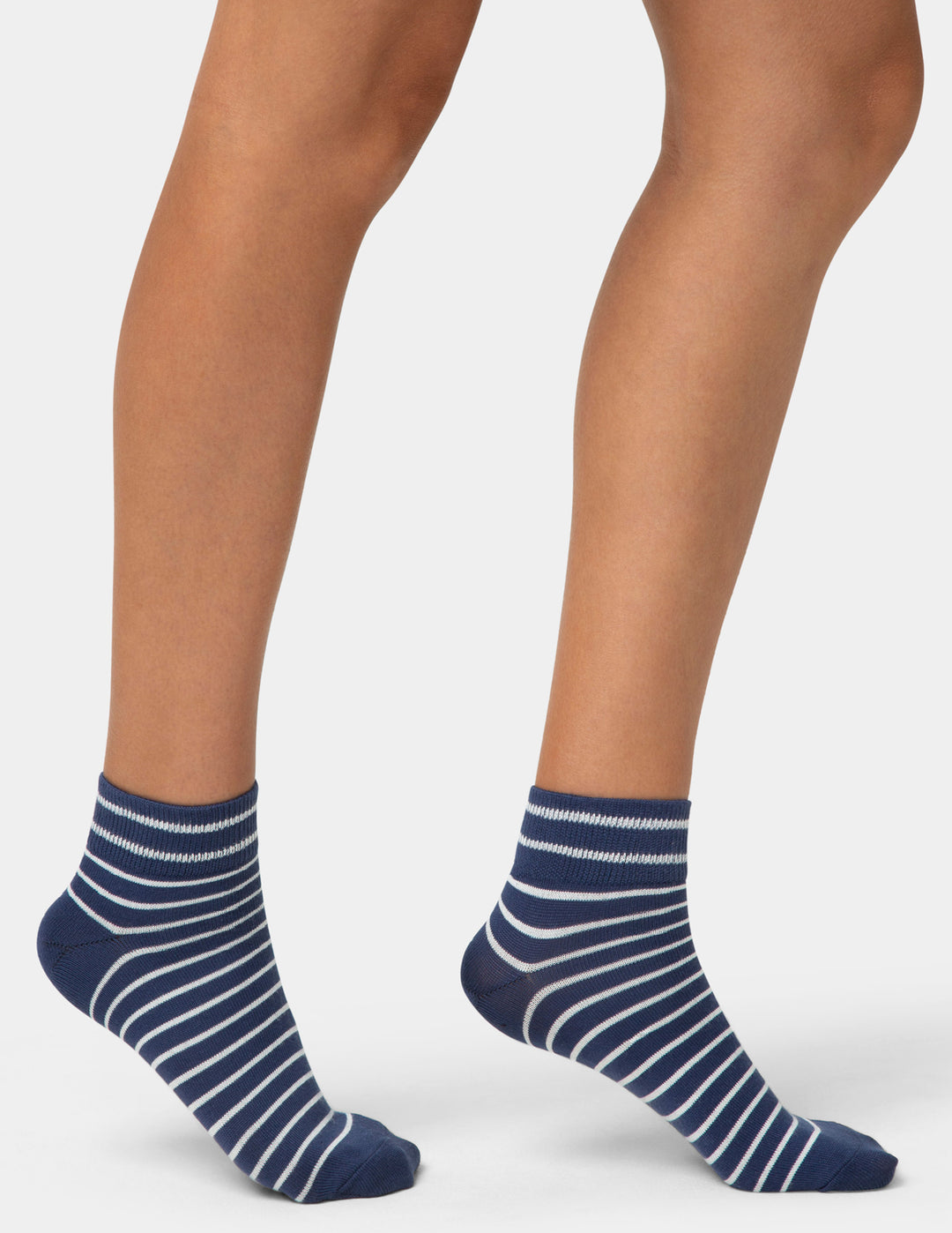 Navy striped socks worn by a person on a light gray background
