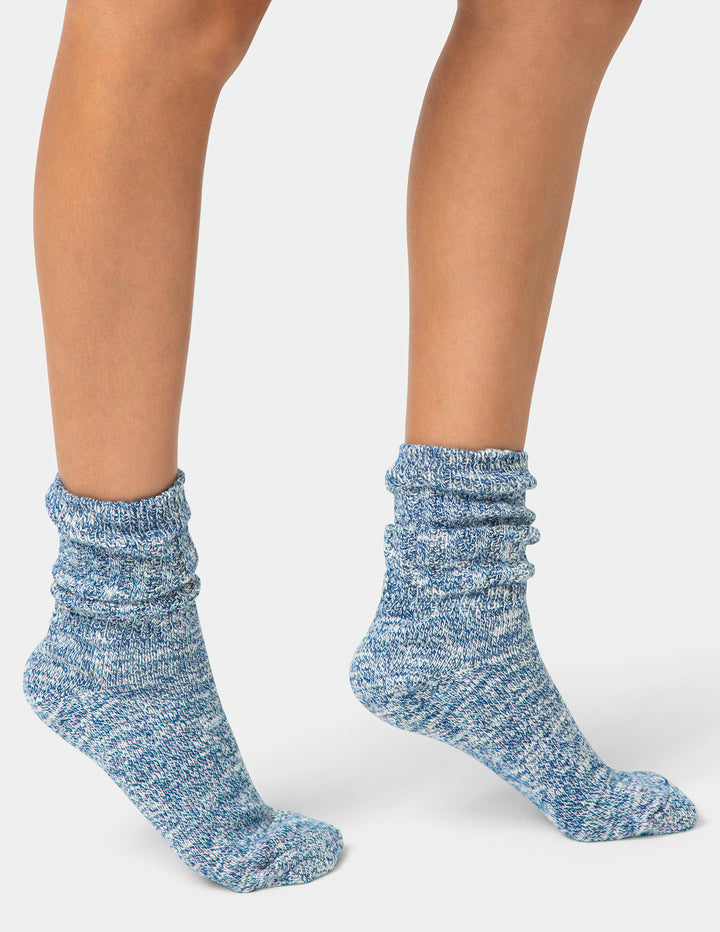 Blue textured socks worn by a person on a white background