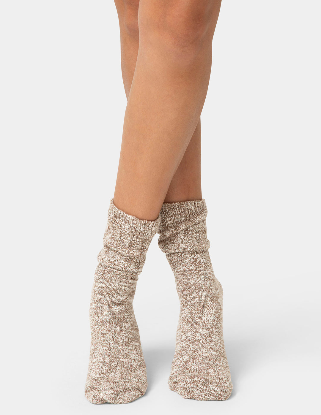 Beige knitted socks worn by a person on a white background