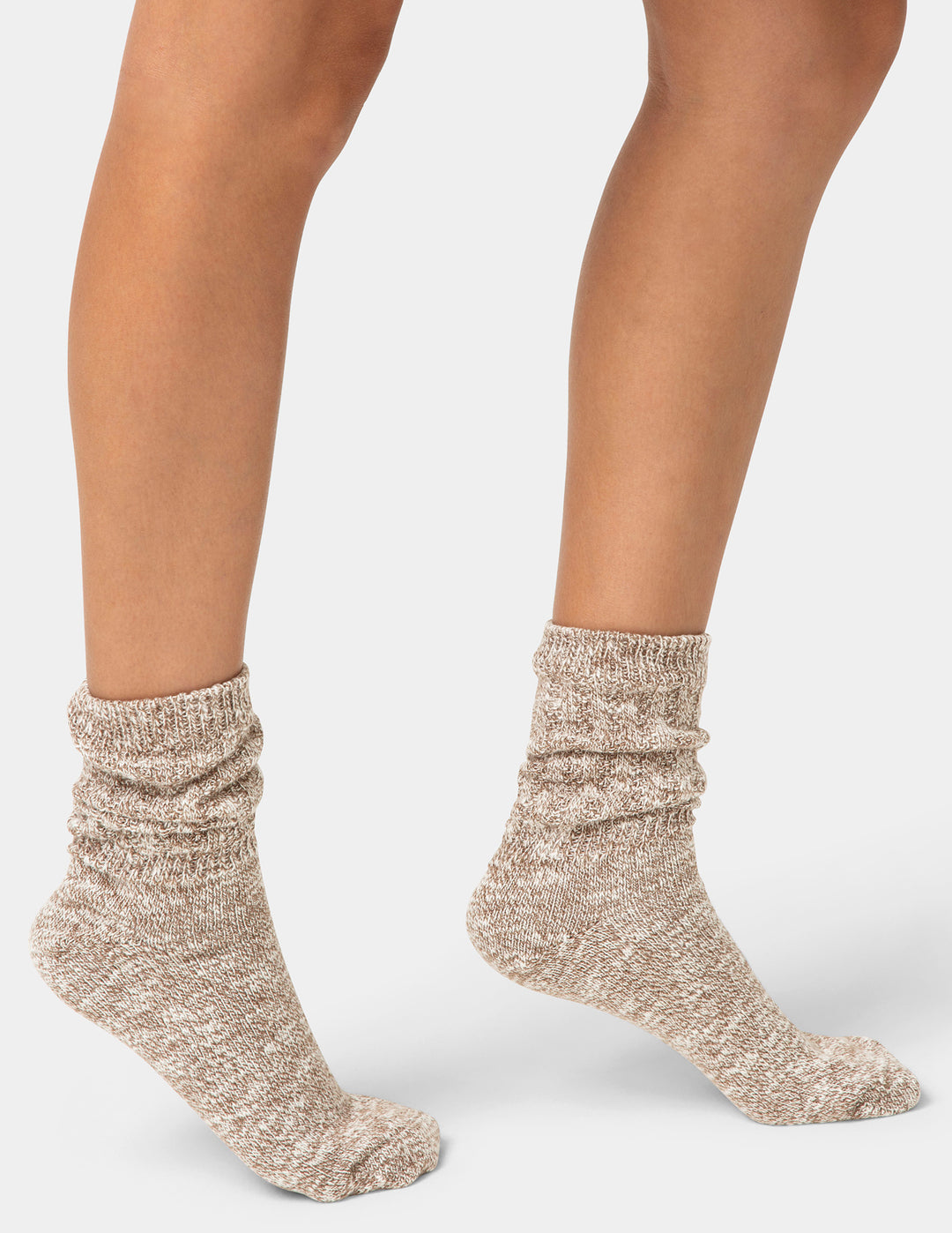 Beige socks worn by a person on a light gray background