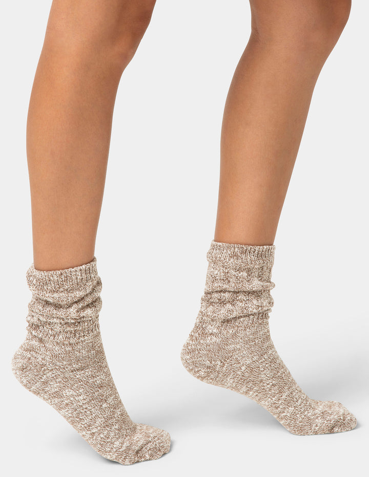 Beige socks worn by a person on a light gray background