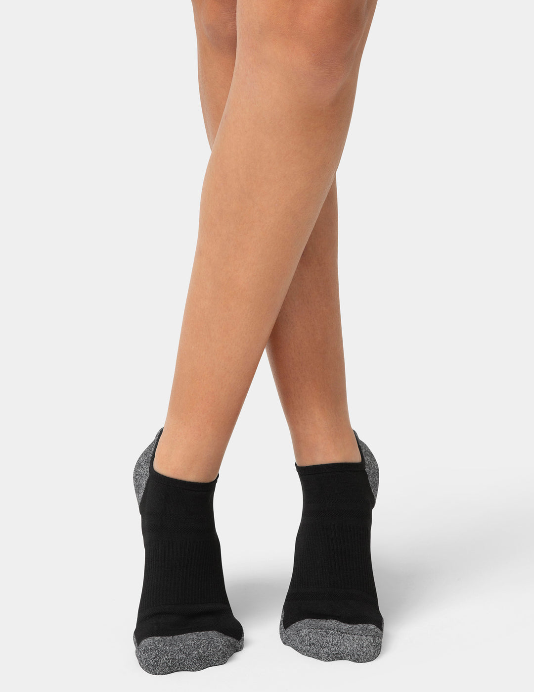 Black ankle socks with gray toes and heels worn by a person on a light gray background