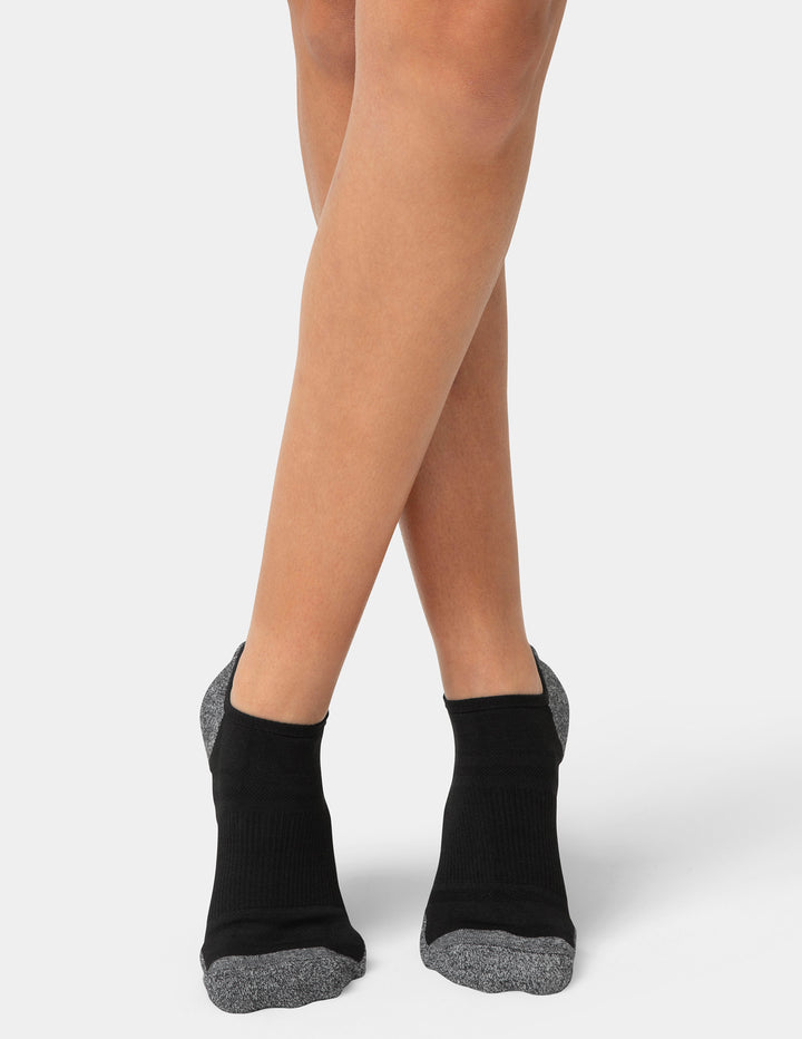 Black ankle socks with gray toes and heels worn by a person on a light gray background